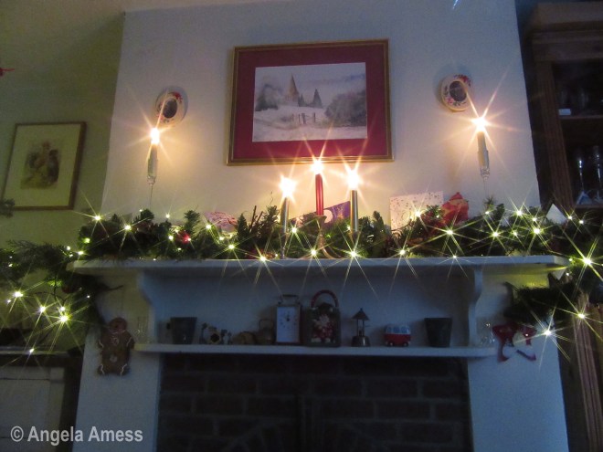Photo of Christmas lights and candles on mantle piece